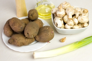 Чтобы приготовить овощные котлеты возьмите: 8 картофелин среднего размера, сырые шампиньоны или любые другие грибы, лук-порей, чеснок, растительное масло, 1 столовую ложку муки, специи, соль.